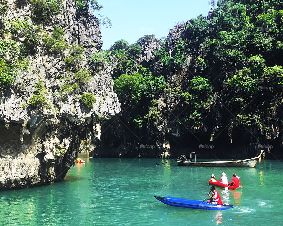 People kayaking among the tropical rocks during the summer vacation 