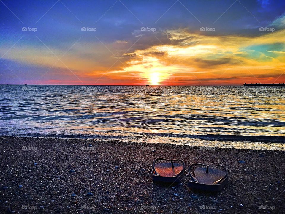 Footwear at beach during sunset