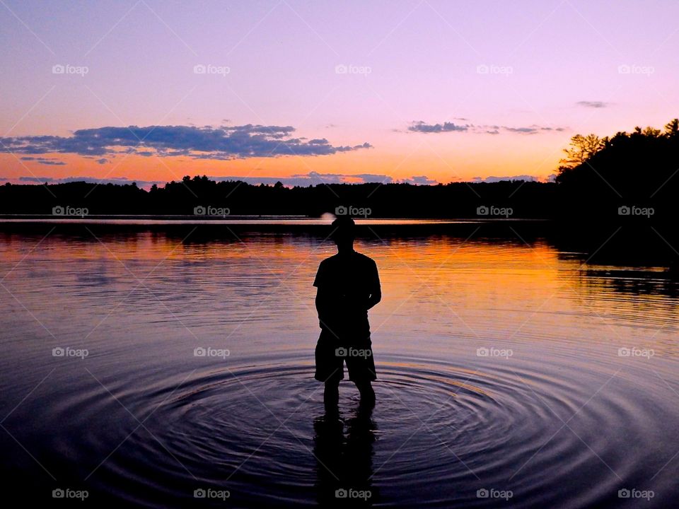 This is a picture of a man in a lake in New Hampshire. It was getting dark as the sun was setting. 