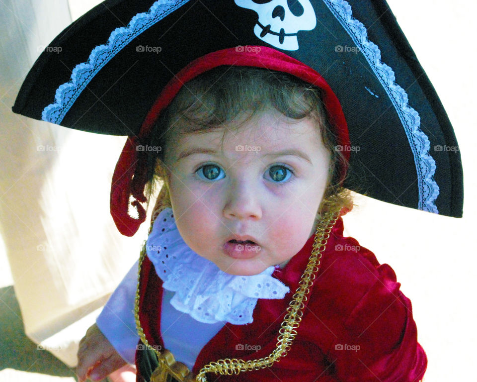 Little girl wearing halloween pirate captain costume