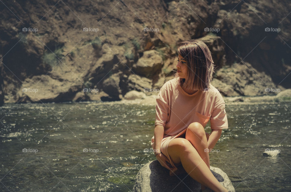 Young woman sitting on rock