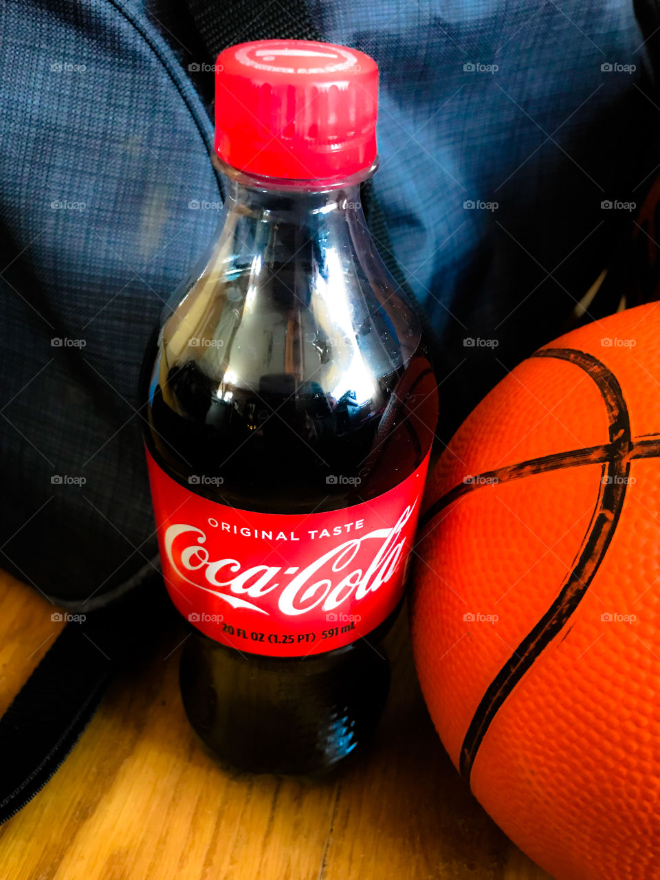 Basketball and gym bag with a soda bottle.