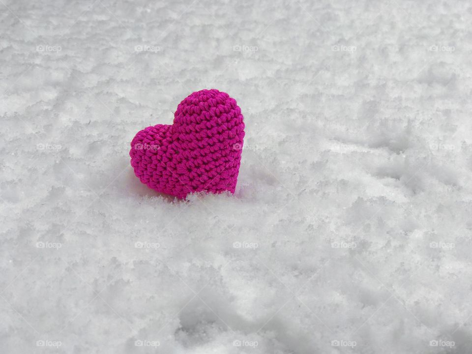Pink heart on the white snow
