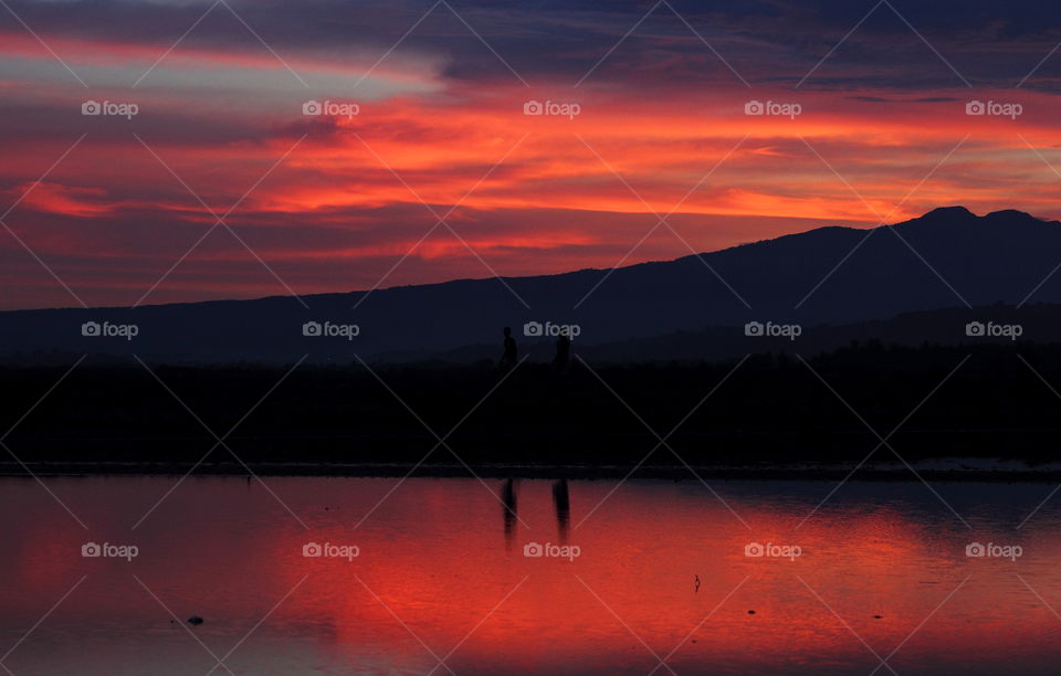 Late afternoon of sunset at the surround of estuarya ponds. Beautiful landscape with the mountain reflection into the water.