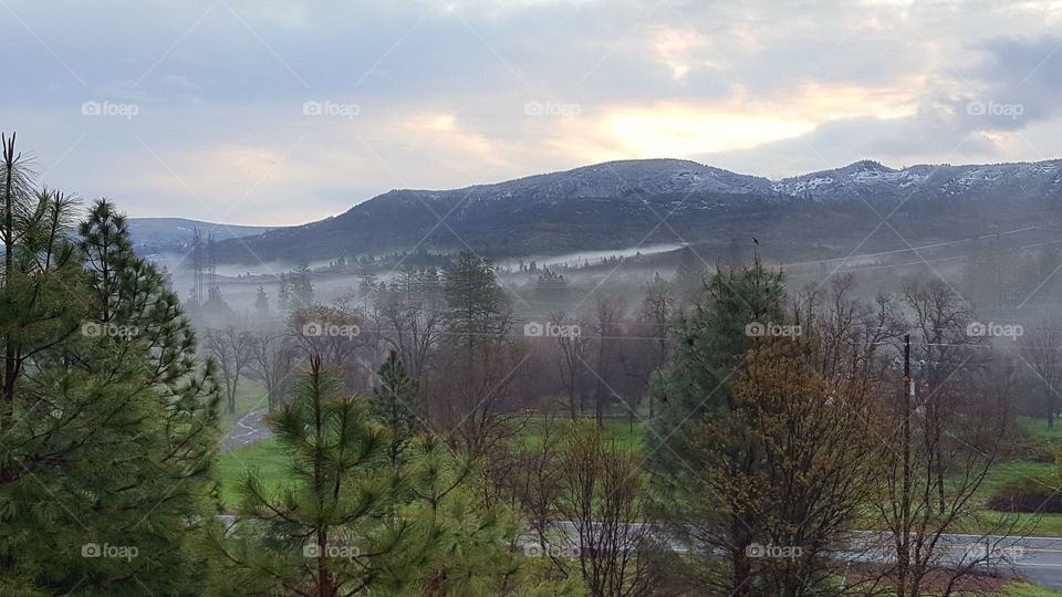 A picture taken from my front porch early morning. I had missed most of the fog here in Shasta County , .CA. Most of the fog had burned away but what little was left was beautiful as the sun began to peek over the mountain.