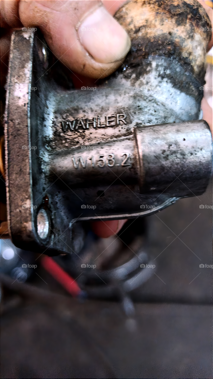 Under the hood. car parts in the hands of a mechanic

￼