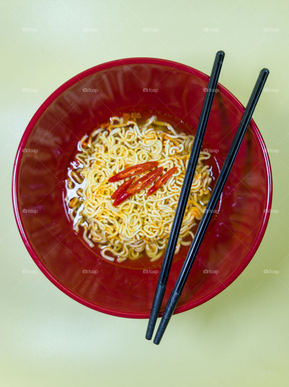 Hot instant noodles in a red bowl and chopsticks