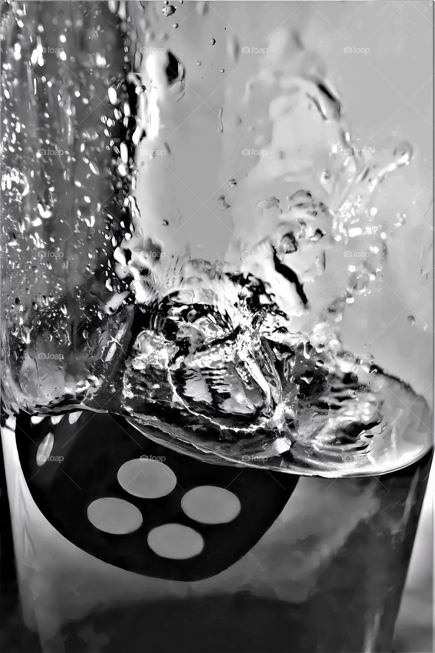 dice splashing in bright clear water black and white close up picture