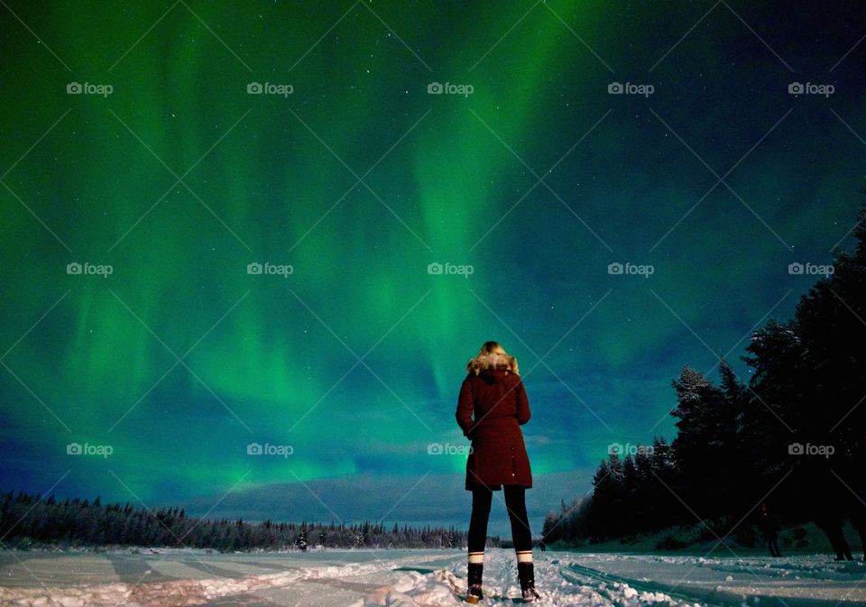 Person standing under aurora borealis at night