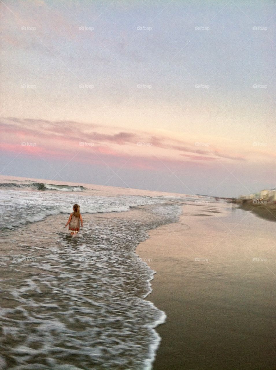 Child Walking on Beach at Sunset