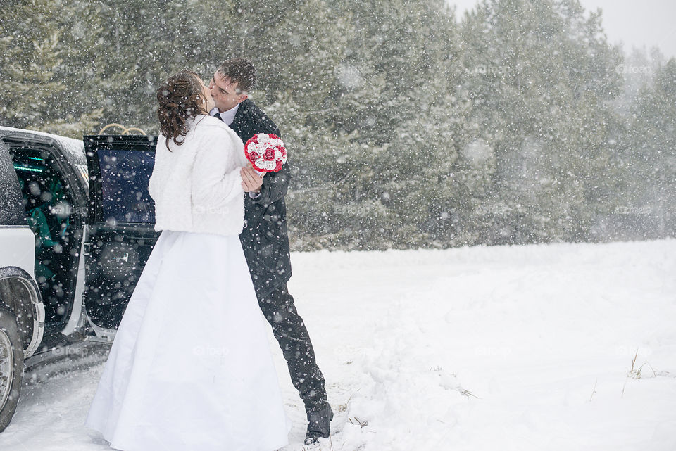 Wedding couple kissing in snow