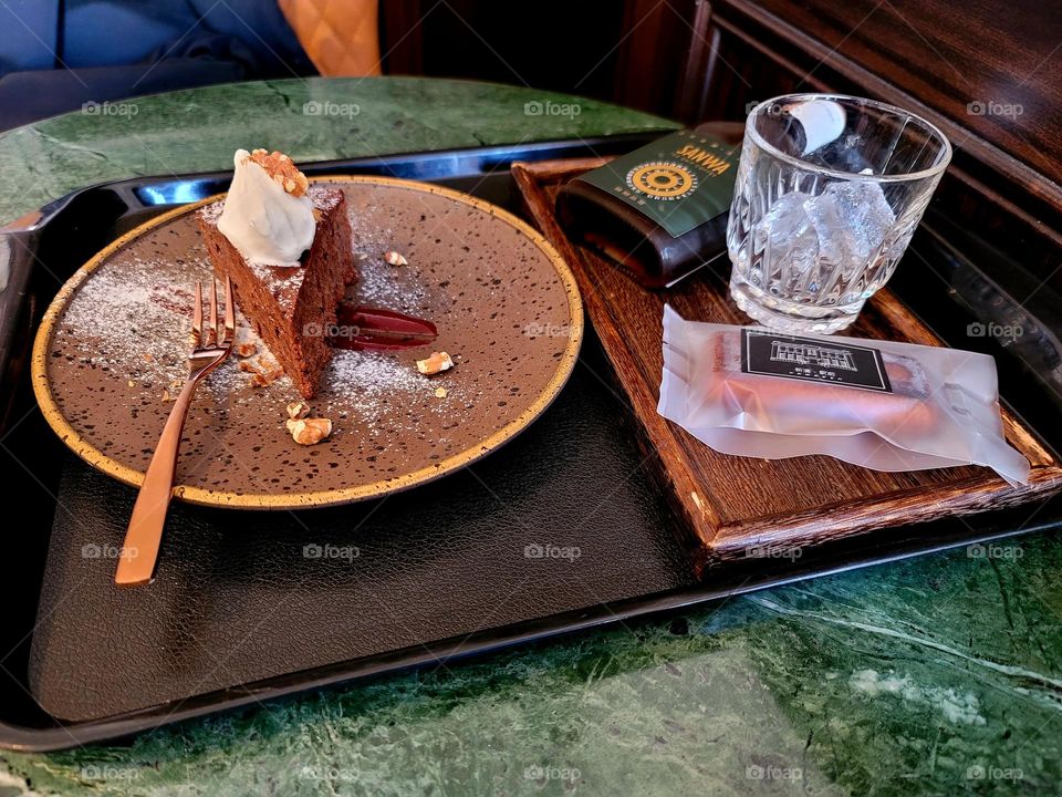 Fresh cream with chocolate cake and glass bottle of coffee