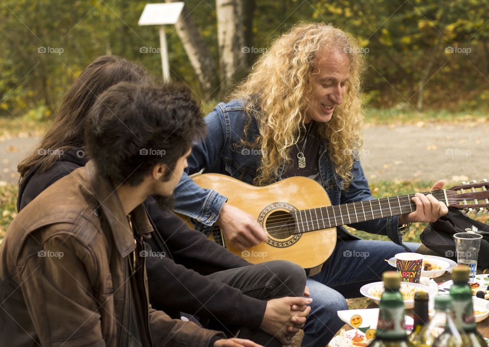 Friends playing a guitar