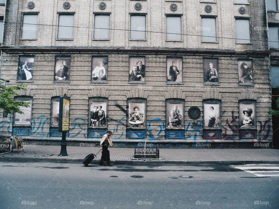 man with a suitcase walking down the street in Kiev