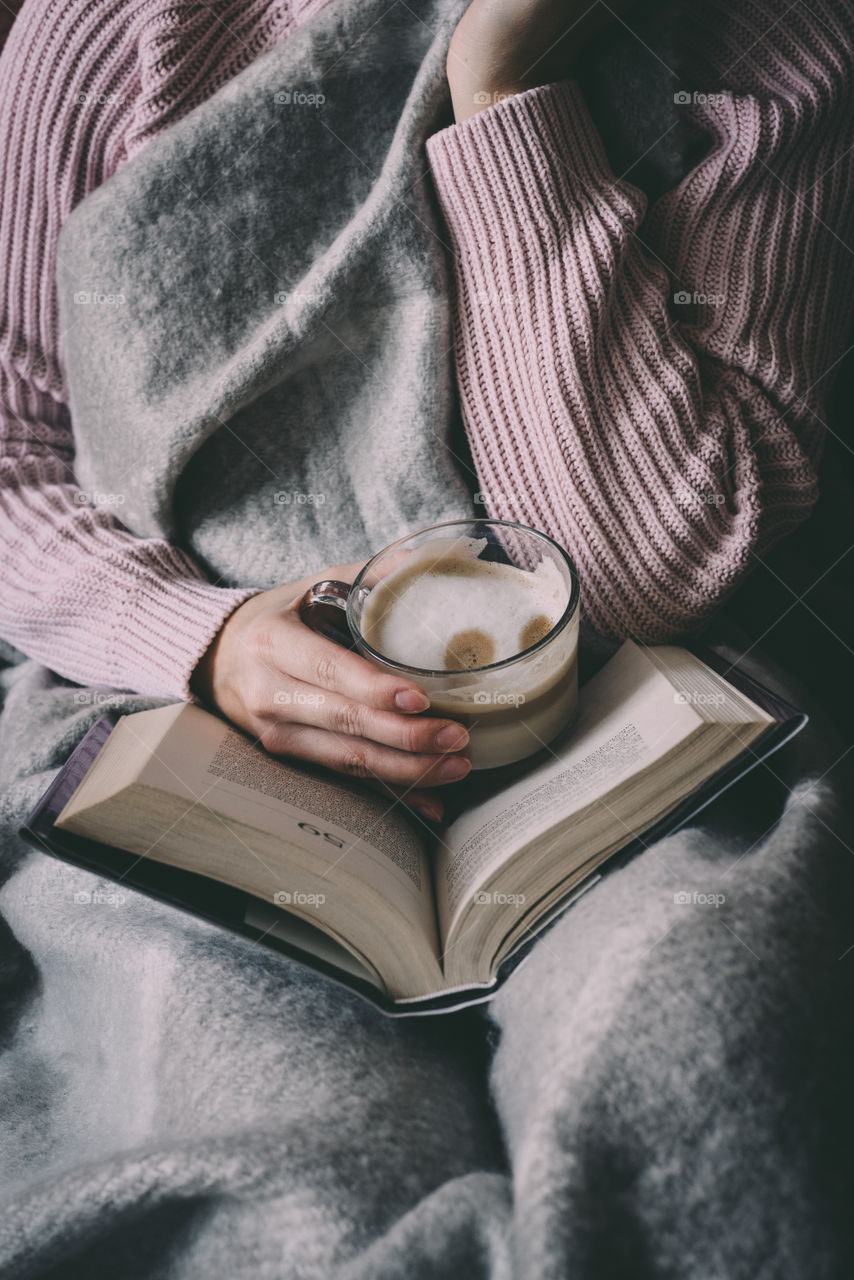 Cosy under the blanket, coffee and a good book in hands.