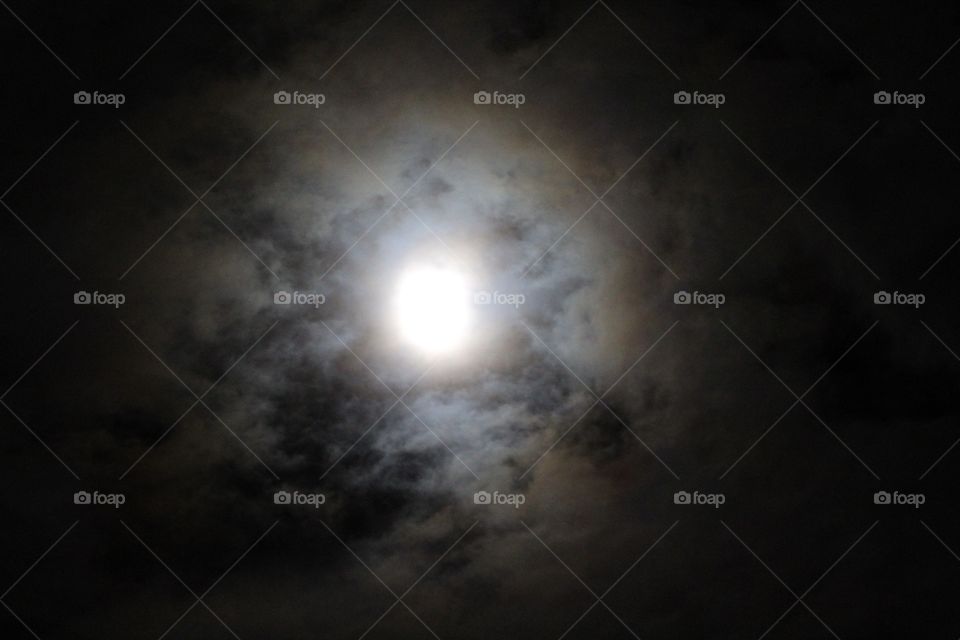 Gray cloud drifting over a full moon