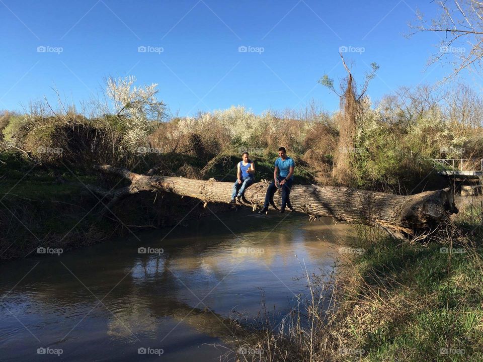 Me and my friend sitting on a fallen tree