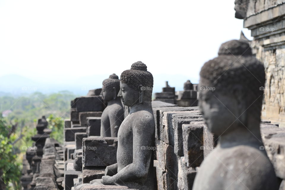 Statues of Buddha look out over the countryside at Borobudur temple, Indonesia