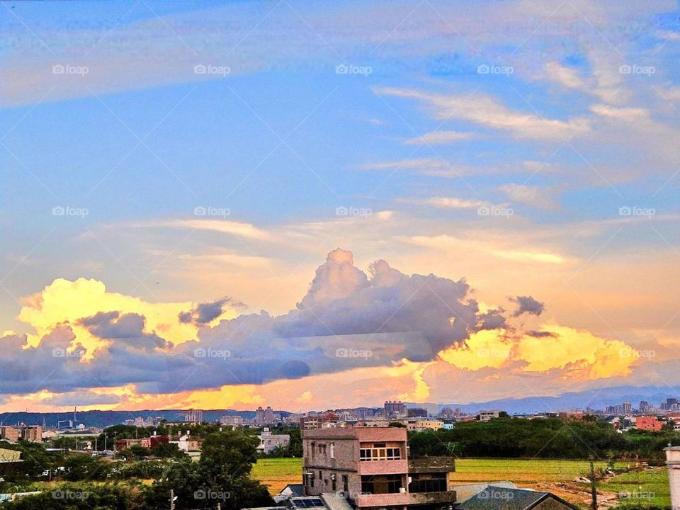Beautiful clouds over the green fields of the village