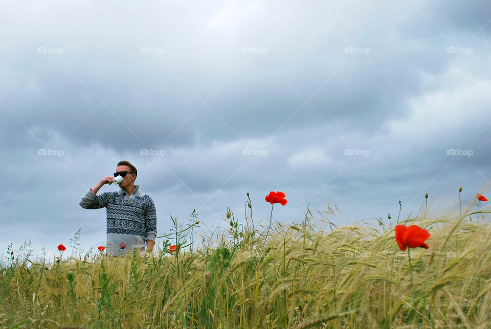 Man Drinking Morning Coffee in a Poppy Field 