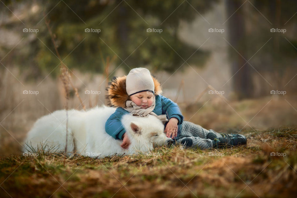 Boy with his Samoyed dog in winter park