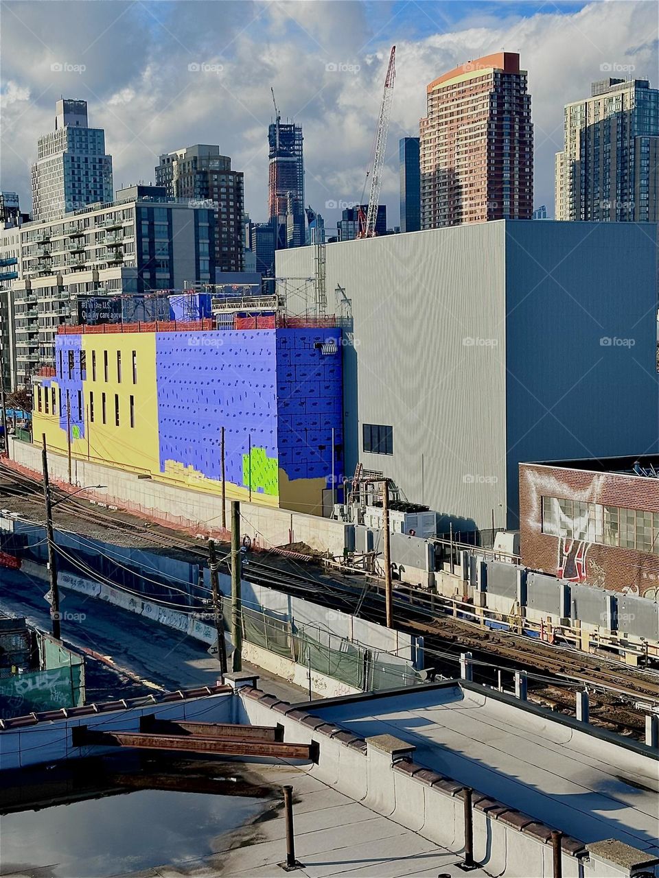 Across the “Long Island Railroad” train tracks is a large gray building that houses the “iFly” indoor skydiving facility after two long years of construction. 2023. Hypnotic Productions