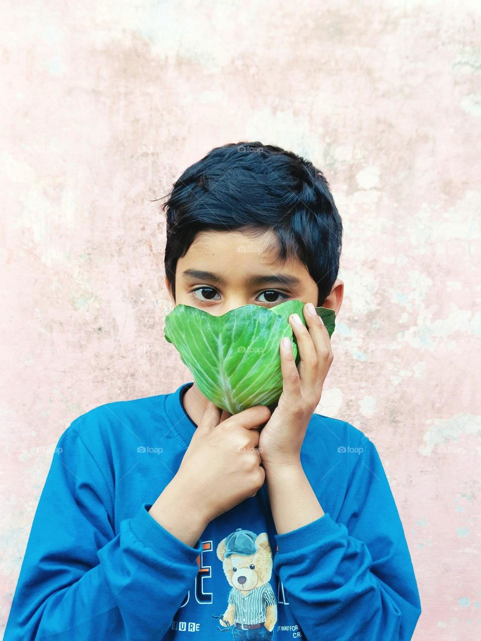 kid using mask made-up of cabbage leaf due to air pollution.