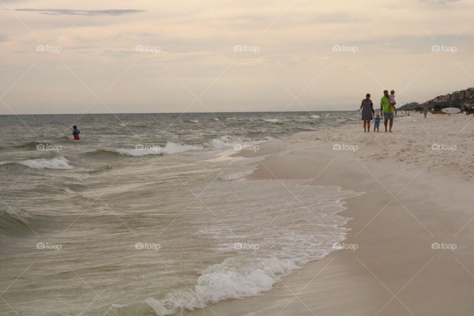 Family walk along the beach 