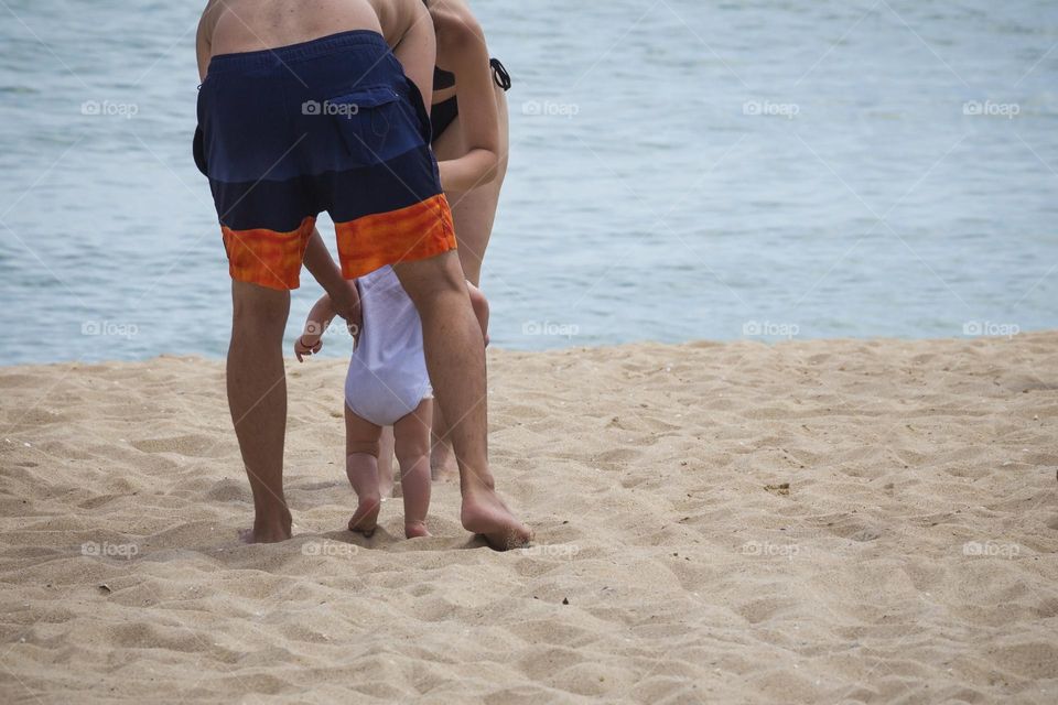 Father holding baby toddler on the beach 