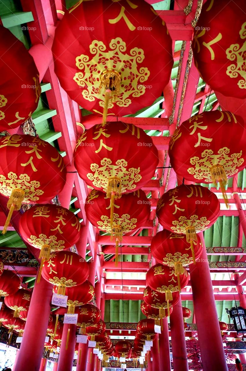 Rows of red and yellow lanterns hanging on the roof of the monastery