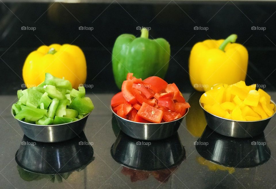 Three colour bell pepper and three colours chopped pepper in bowls 