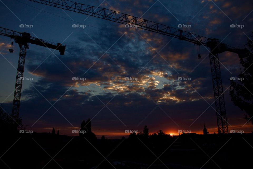 Silhouette of crane against dramatic sky