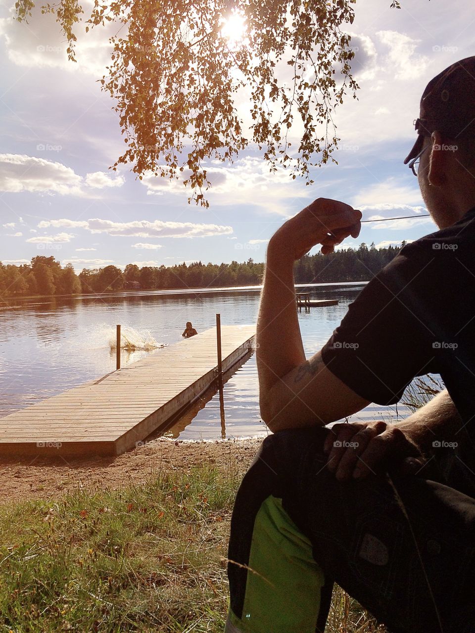 Keeping watch. Father keeping watch while his children plays in the lake