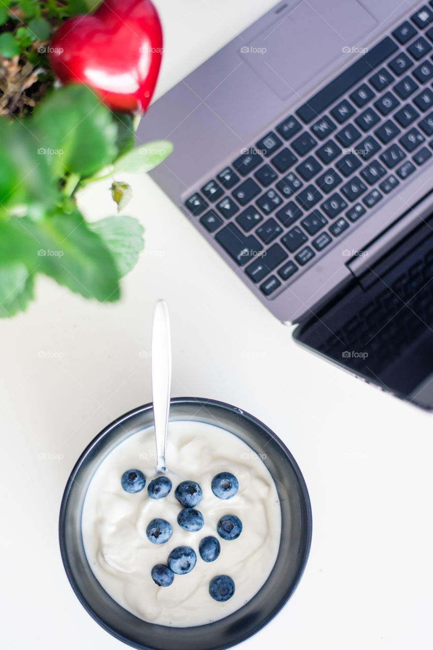 View of a desktop with a portion of blueberry yogurt 