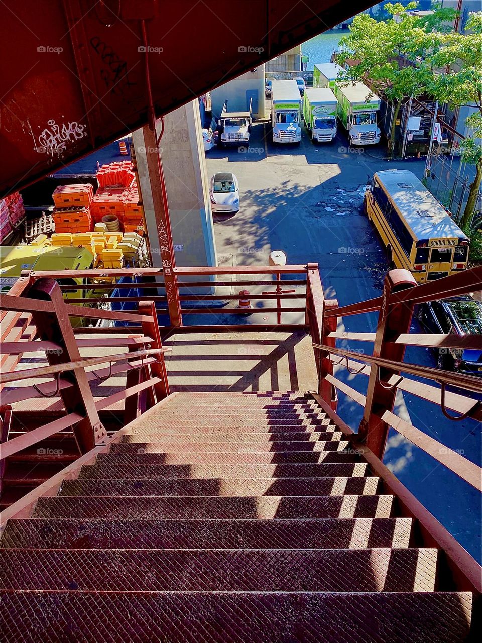 The rippled shadows cast on the steps of the red metal staircase of the „Pulaski Bridge“ are quite dramatic. The angled element due to the from above perspective juxtaposes the parallel lines of the metal railing nicely. 2023. Hypnotic Productions