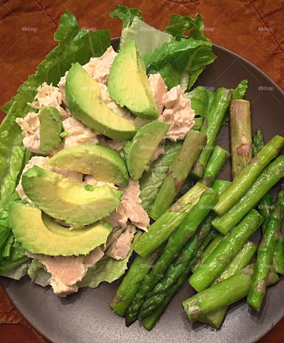 Healthy lunch with green as the predominant color.  Chicken, lettuce, avocado and asparagus, yum!