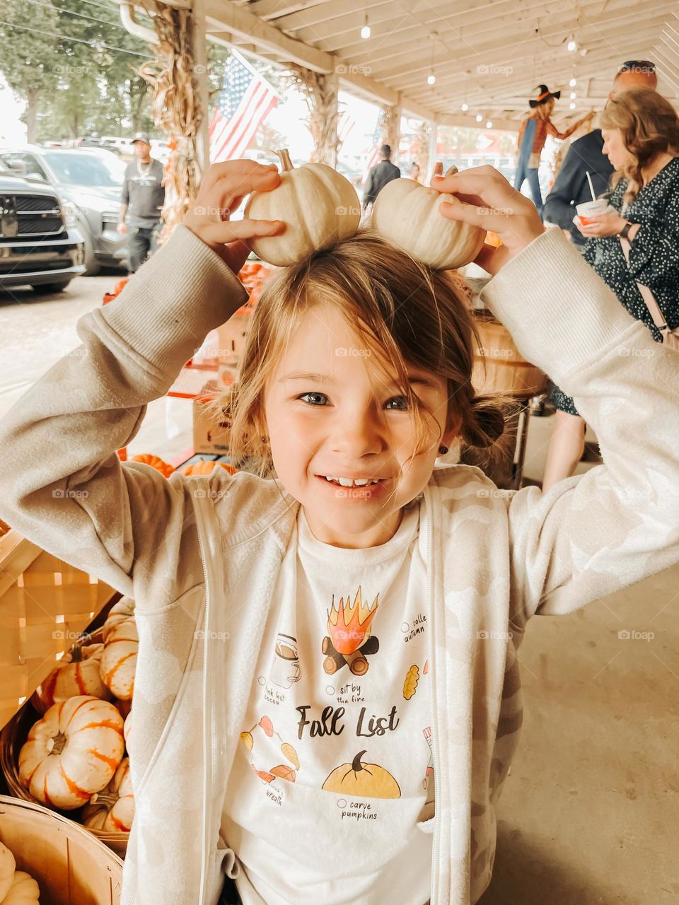 A girl holding pumpkins on her head