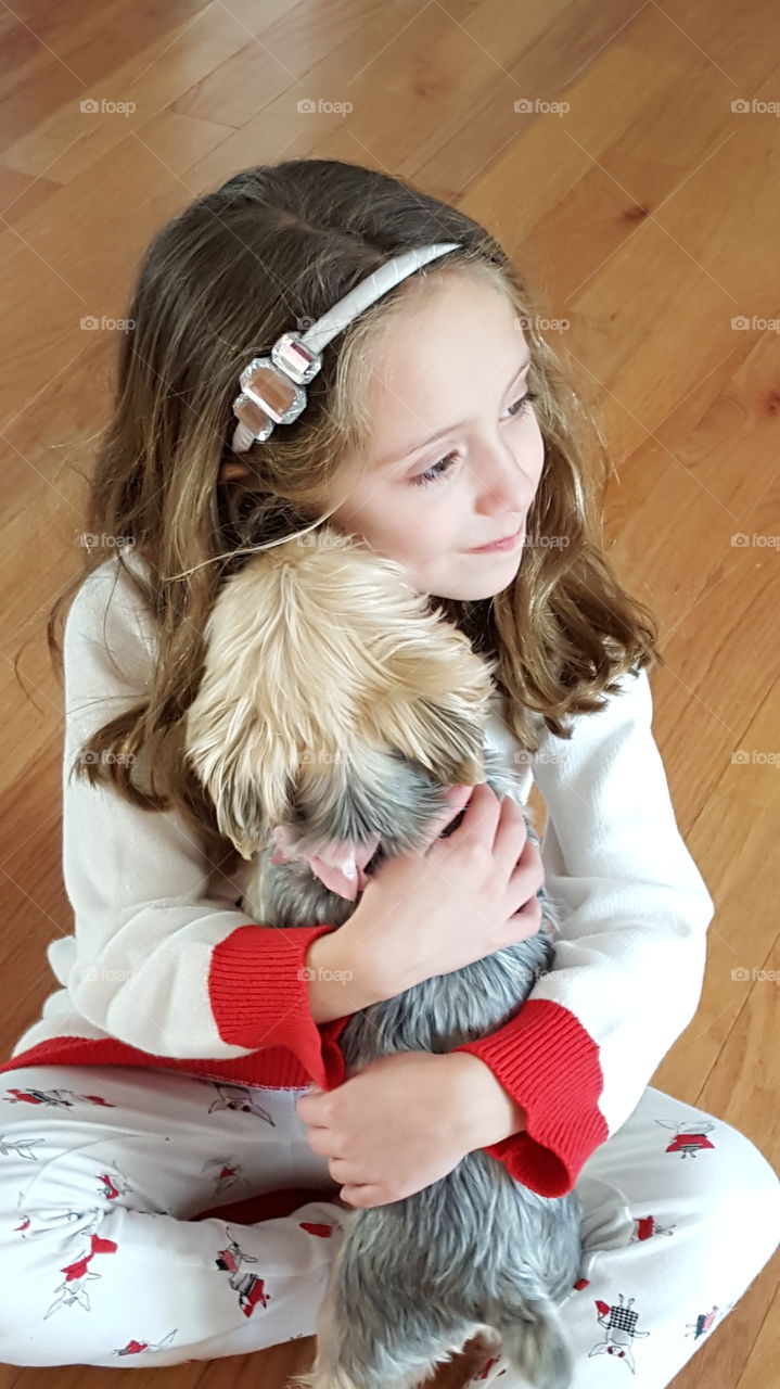 Little girl sitting on floor with puppy