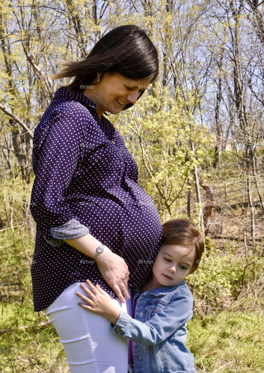 Little girl hugging pregnant mom