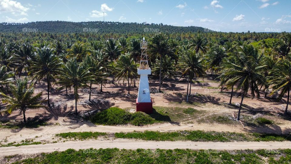 The incredible lighthouse in Praia do Gunga, Brazil. The coastline full of palm trees, beaches and crystal clear water
