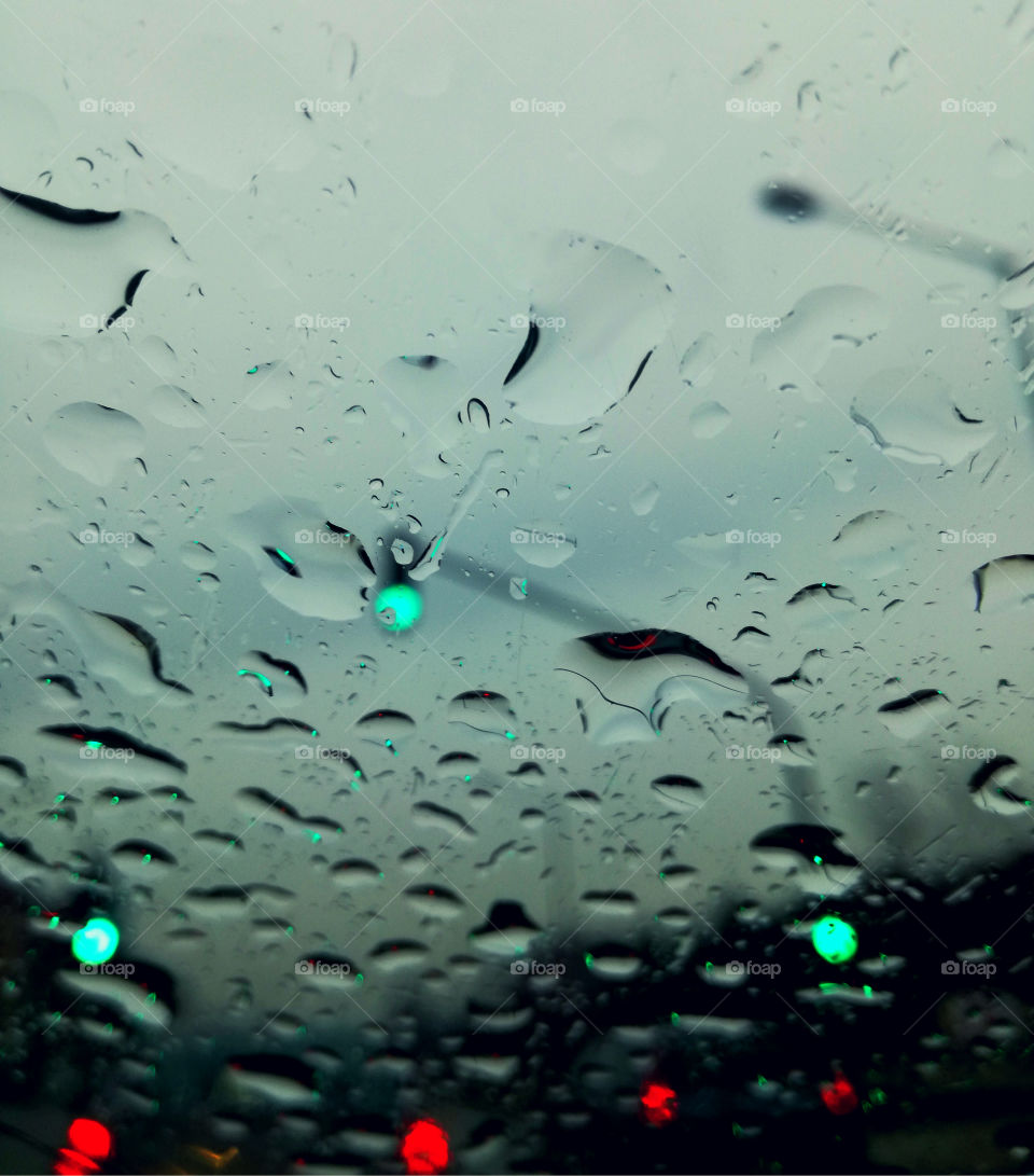 rain drops on the glass of the car and traffic lights