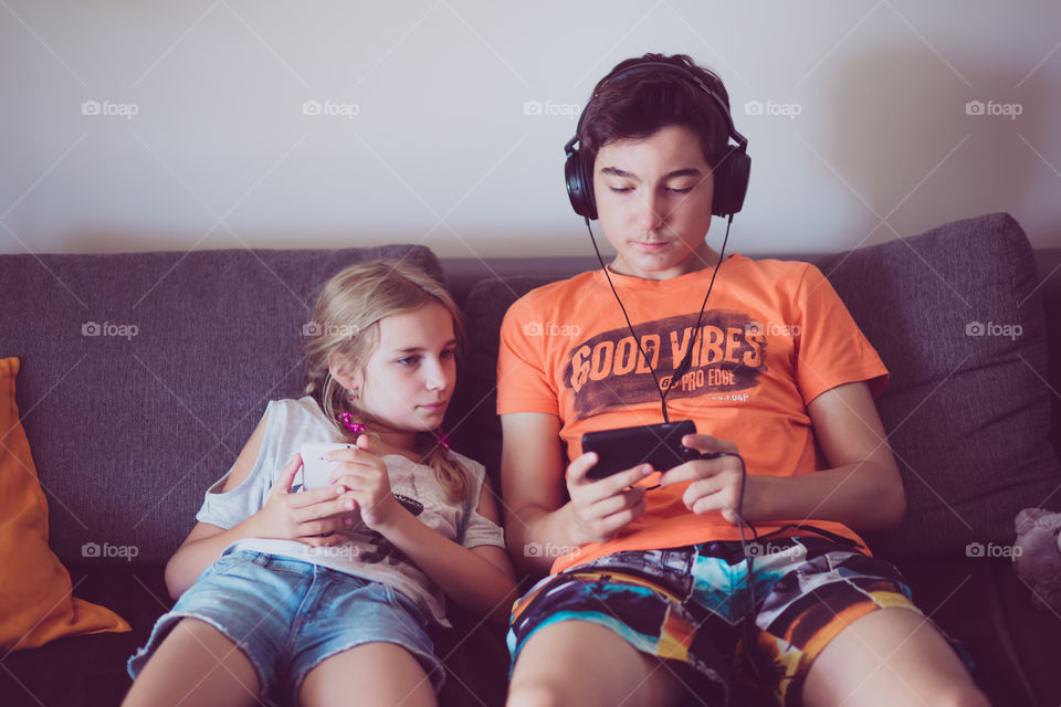 Brother and sister watching video in smartphone