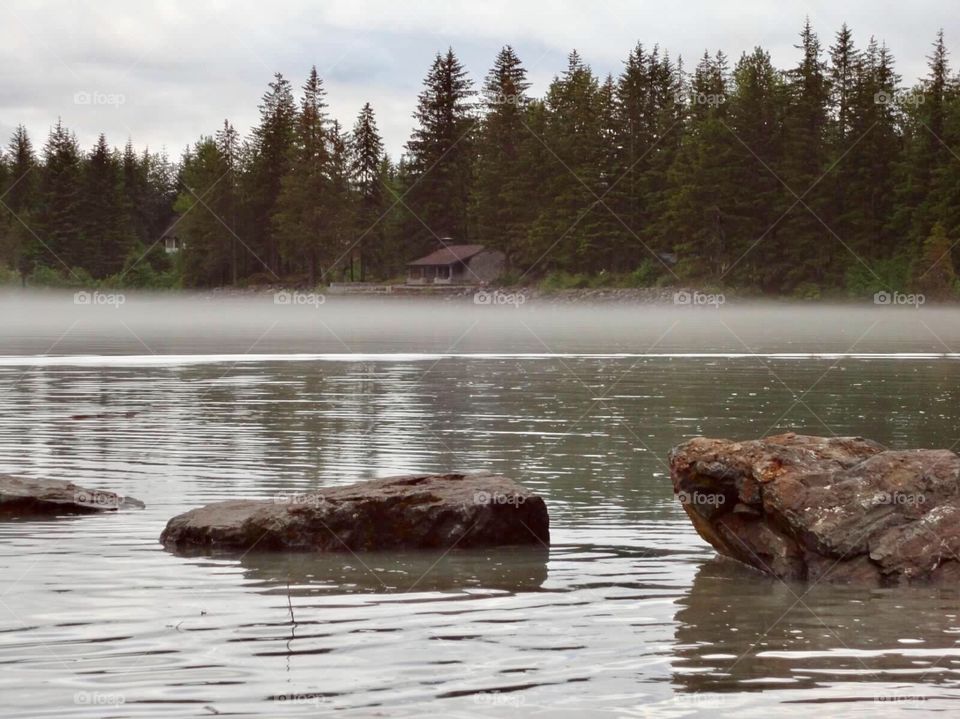 Cabin by the lake with fog