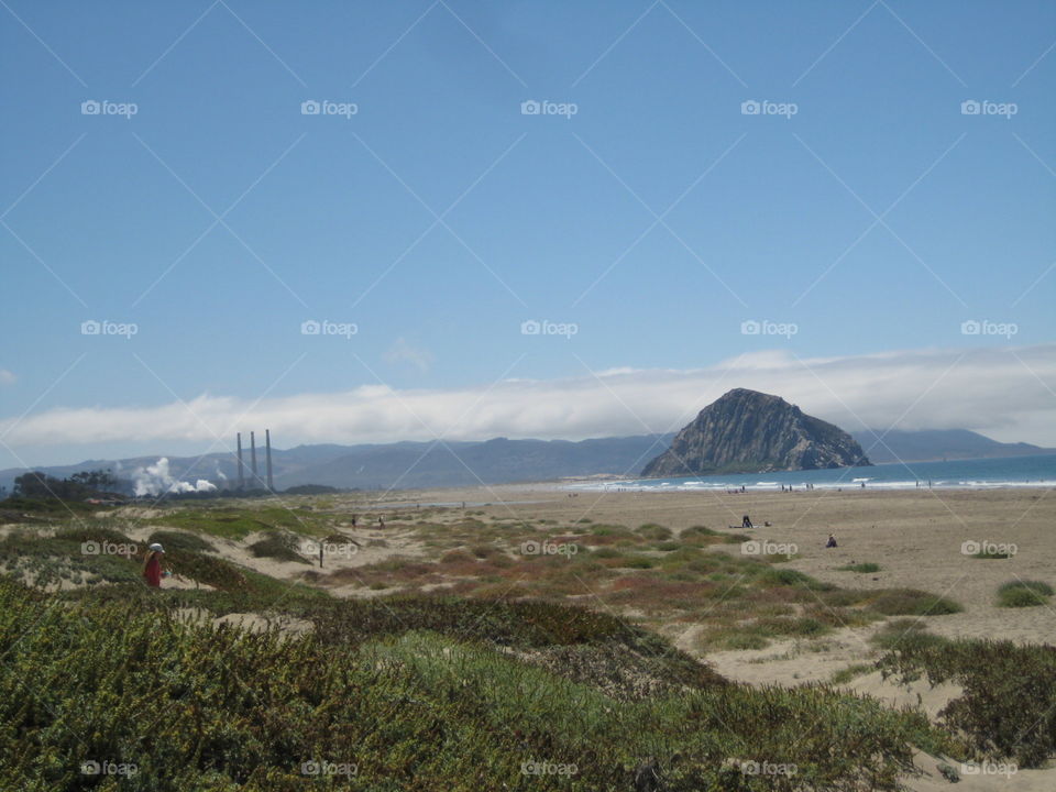 Beach with a big rock. Lava plug near the coast