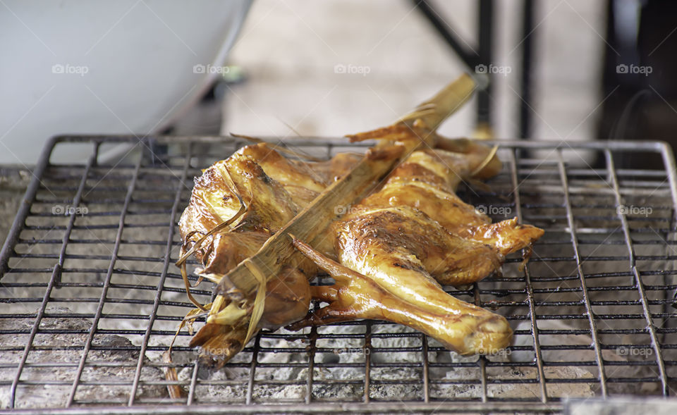 Grilled chicken in bamboo on the grill of the stove.