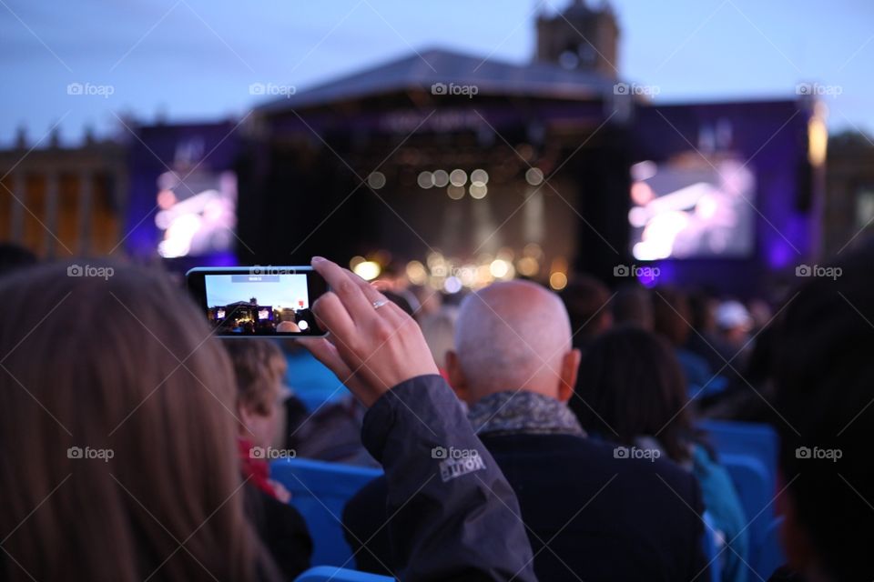 Concert. Woman takes a photo of a concert stage