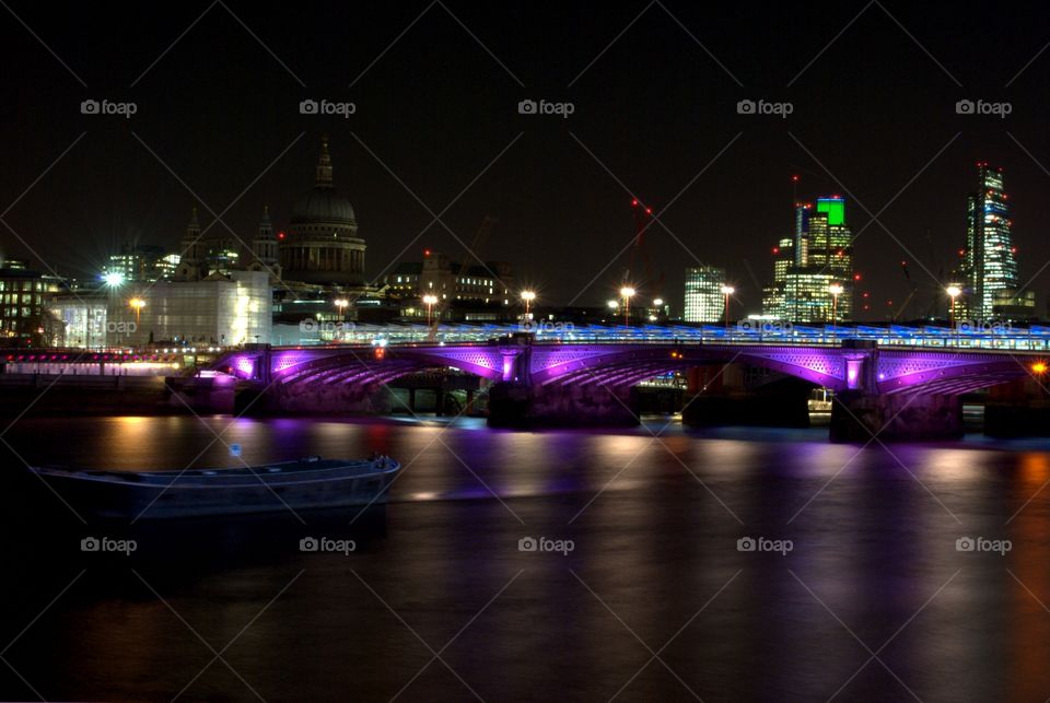 Blackfriar Bridge in London by night,  reflecting in the River Thames