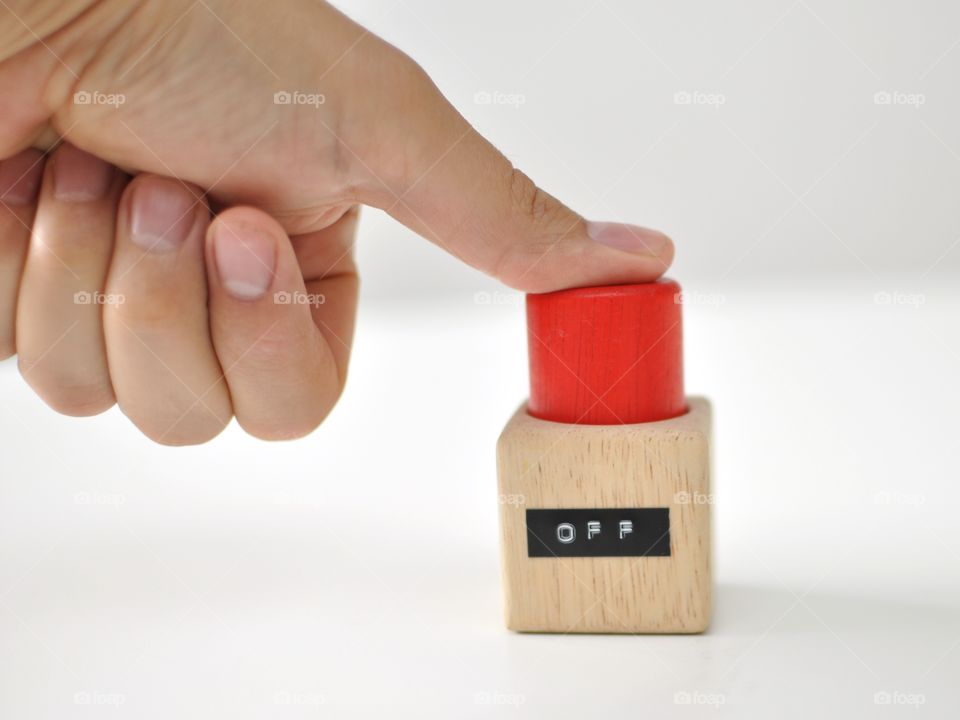 Thumb pressing red OFF-button