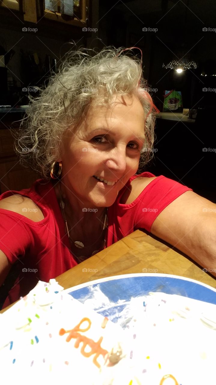 Girl with leftover birthday cake, smiling, pink color in hair. Happy expression on womans face😀🎂