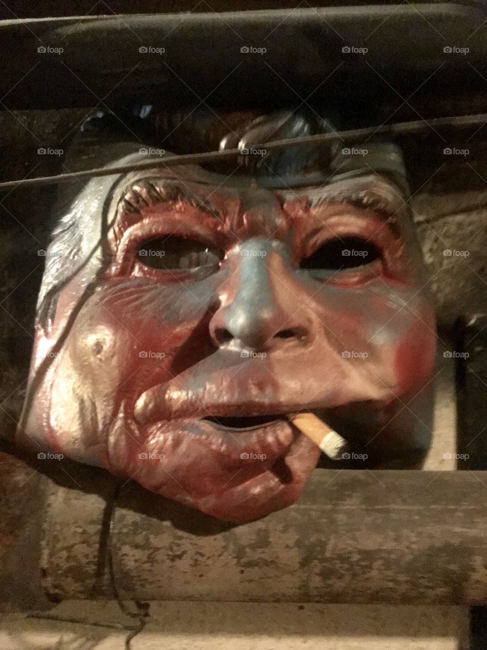 An old Reagan mask takes on an eerie composure, including a glass eye and cigarette, after years within a dark cellar beneath businesses in downtown Pocatello, ID.